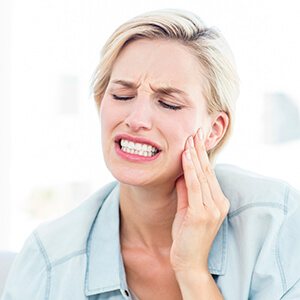 Woman in need of emergency dentistry in Weatherford for toothache