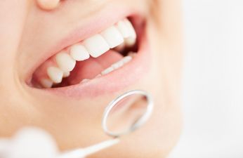 Dental patient smiling during a visit with a cosmetic dentist